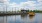 A yellow boat in the river near a dock